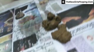 Ebony babe pooping on a newspaper