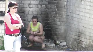 Two girls peeing in public