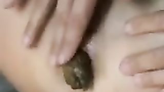 Moving her wet clit while shitting