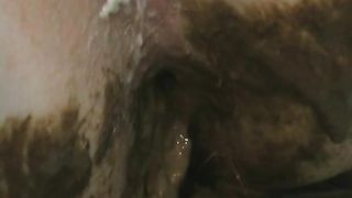 Shitting on a green bag in the bathtub