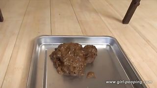 Brunette babe shitting on a metallic plate