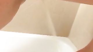 Hairy girl peeing in the tub while standing