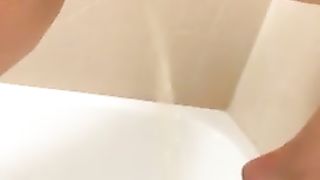 Hairy girl peeing in the tub while standing