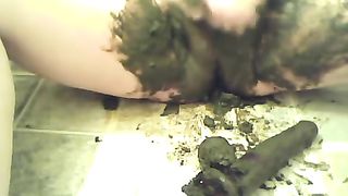 Chubby woman smearing black shit on her shaved pussy