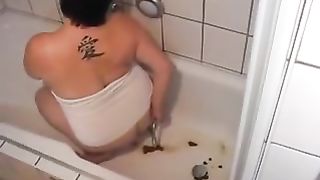 Chubby girl doing enema in the tub