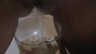 Sexy tanned girl shitting into a wine glass