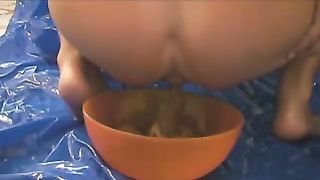 Hot babe shitting in an orange bowl