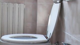 Lady sits half naked on a toilet while pooping