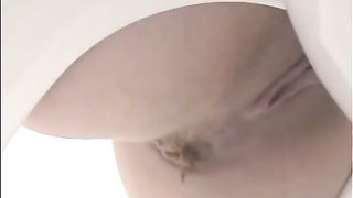 Beautiful girl pooping on a white plastic homemade toilet