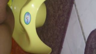 Shaved girl pooping in a yellow potty
