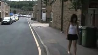 Brunette girl peeing between two houses