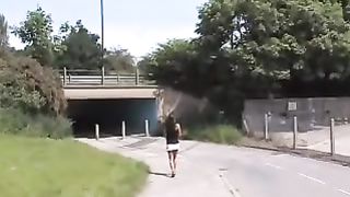 Beautiful brunette peeing under bridge