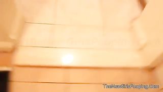 Sexy young brunette shitting on bathroom floor