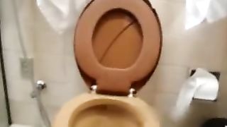 Brunette nurse pooping over toilet