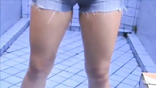 Teen girl peeing in her blue shorts