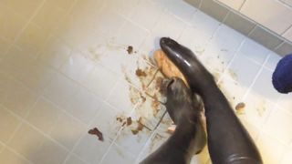 Rubbing shit on her latex feet
