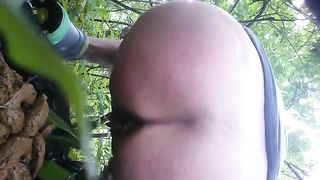 Shaved milf shitting in nature
