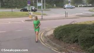Blonde woman in green dress peeing