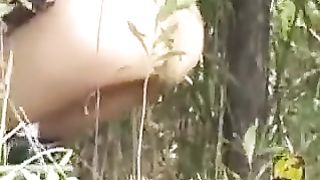 Slim girl shitting in a park