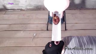 Feeding her male slave through a plastic tube