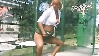 blond pisses outside at a bus stop