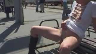 pissing on a bench outside next to the road