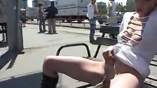 pissing on a bench outside next to the road