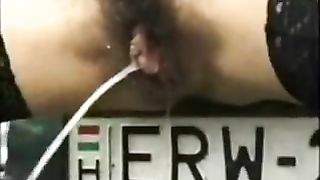 Woman Peeing in front of her car