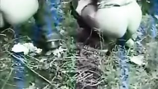 Two hot girls poop in a forest