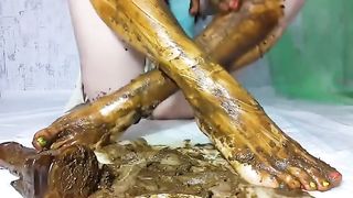 Dark haired babe smears shit on feet