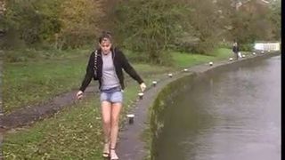 pissing next to the bridge lifting her skirt