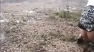 Girl peeing on the side of the road
