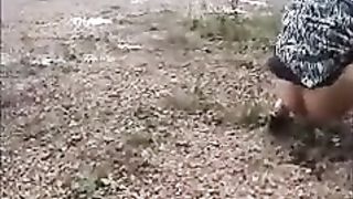 Girl peeing on the side of the road