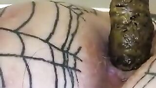 Woman covered in fishnet stockings squats on a pile of shit