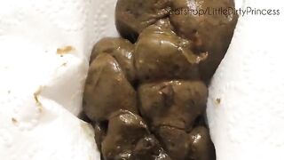 A girl paints her belly with shit in a bathroom