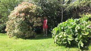Lovely brunette gal pooping in green garden