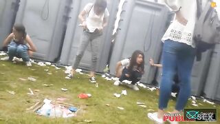 A girl poops at a festival while her friend stands by side