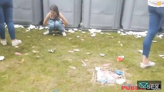 A girl poops at a festival while her friend stands by side