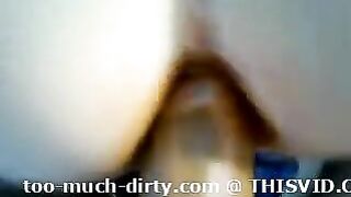 A closeup of a woman taking a shit on a toilet