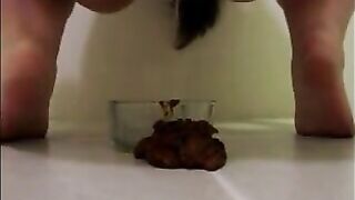 Mature woman pissing and shitting in the glass bowl