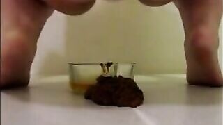 Mature woman pissing and shitting in the glass bowl