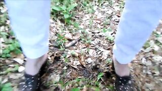 Mature lady poops in the forest next to the road