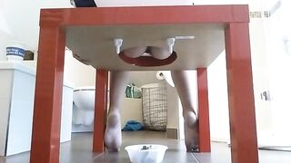 Woman takes a massive shit in a bowl under a table