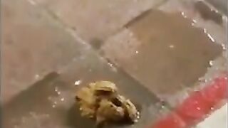 Girl pisses on floor while holding railing in a public place