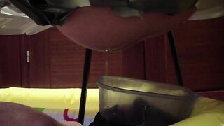 Woman crouches over bucket, pisses into it