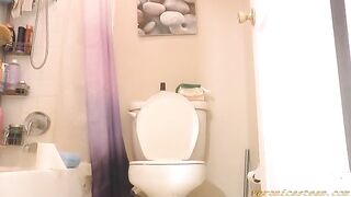 Woman taking a shit on the toilet in the bathroom