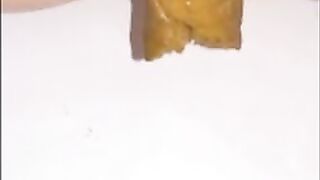 Woman shits a long piece of shit into a bowl