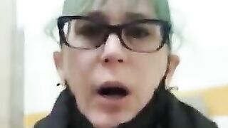 Mature woman with green hair and glasses gasps in shock