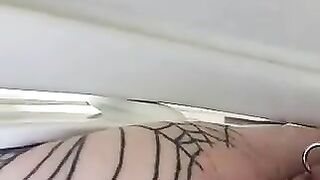 Girl in fishnet leggings squats with the ass out