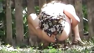 Girl taking a shit near a fence